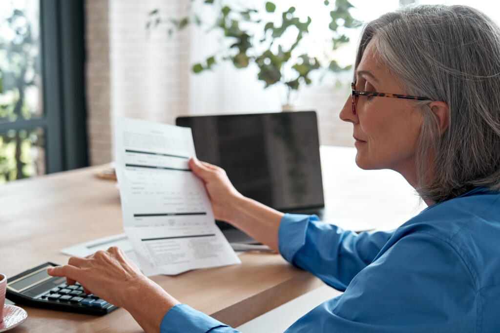 Acuity Advisors and CPAs consultant providing transactional and controller services to Lancaster, PA client using calculator and laptop on desk
